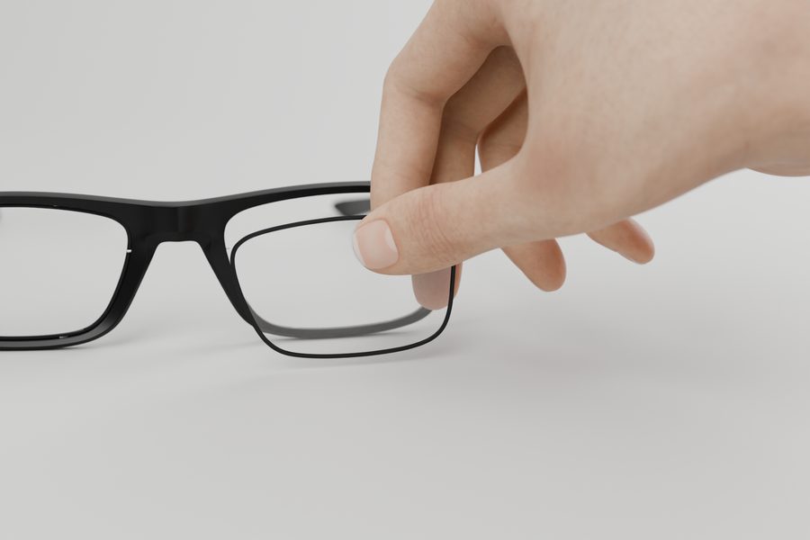 A hand holds a lens next to the frame